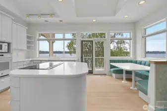 Pristine kitchen with center isle and built in seating area.  Also a pantry, nor visible in this photo.