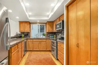 Kitchen with oak hardwood flooring and cabinets.  Double doored pantry has tons of space for all your Costco purchases.