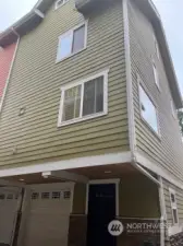 The back of the townhouse with view of garage and separate entrance.