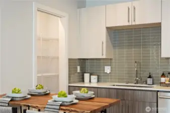 Gourmet kitchen with tile backsplash, quartz counters, stainless steel appliances, induction cooktop, and walk-in pantry.