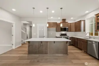 Kitchen features Cocoa-stained Maple Cabinets and Quartz countertops and a large pantry with frosted glass door.
