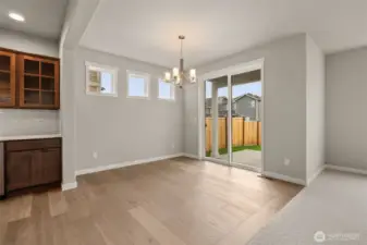 Dining area with high set transom windows for natural light features hardwood flooring.