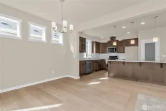 Dining area with high set transom windows for natural light features hardwood flooring.