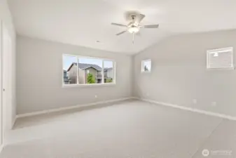 Large primary bedroom featuring a standard ceiling fan and soft carpet for comfort.
