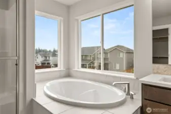 Primary bath also offers a beautiful, large soaking tub with tile surround.