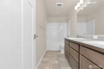 Main Full bath with double vanity undermount sinks with contemporary fixtures, quartz countertop and tub/shower.