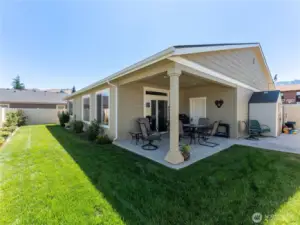 Cover patio open to fenced backyard.