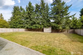 Tall fence and mature trees give back yard privacy.