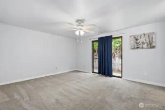 Primary bedroom with slider out to back fenced in patio area