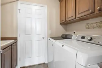 The main floor laundry room with utility sink hosts lots of storage and is conveniently located just off of the garage entry into the home.