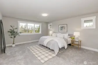 Spacious Primary Ensuite with sweeping views of sunsets & evergreen trees. Photo is of the staged model, the same 2,958 sf floor plan as the listed home.  Colors vary.
