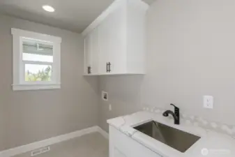 Deluxe laundry room with sink, cabinets & window.