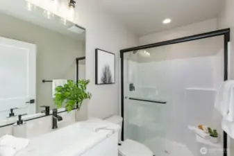 Daylight basement guest bathroom. Photo is of the staged model, the same 2,958 sf floor plan as the listed home.  Colors vary.