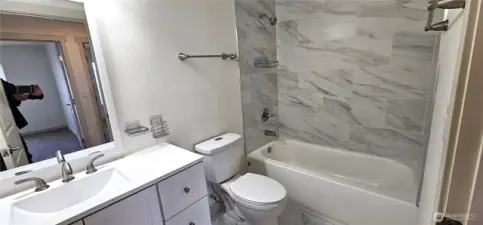 Main bath with tiled tub shower surround