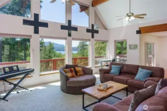 Sunlit living room welcomes you with floor-to-ceiling west-facing windows and captivating forest-to-sea views