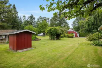 Looking across the rear yard with the well pump house, play house and the work shop beyond.