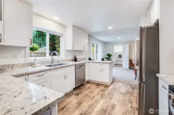 The kitchen features new quartz countertops, white soft-close cabinets, new stainless appliances, and new fixtures.