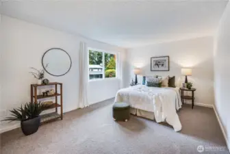 On the upper level of the home, you'll find the primary suite. It is spacious enough for a full furniture ensemble.