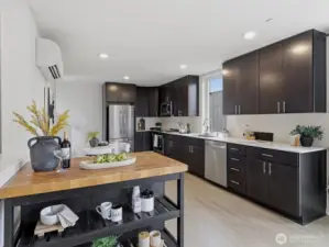 The kitchen has sleek stainless steel appliances and quartz countertops