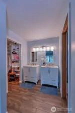 Primary offers new vanities w/dual sinks, mirrors and lighting. To the right is your full bath and to the left is your walk-in closet.