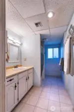 Spacious 3/4 bath featuring generous counterspace, floor to ceiling storage, and a convenient drying rack.