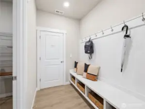 Built-in dropzone with bench, cubbies, and coat hanging area.    Photo is representational. Actual home is under construction and finishes and colors will vary. See site agent for details.