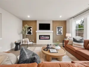 Open concept family room with cozy fireplace and loads of windows. Photo is representational. Actual home is under construction and finishes and colors will vary. See site agent for details.