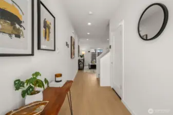 A grand entrance that makes a statement! This hallway welcomes you with warm wood tones, modern lighting, and an open flow leading to the heart of the home.