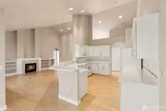 View from dining towards kitchen and living area. Maple hardwood flooring throughout.  Vaulted ceilings.