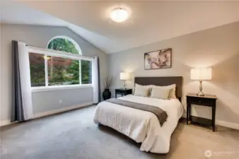 1st of 2 primary bedroom suites. Vaulted ceilings enhance the roomy space.