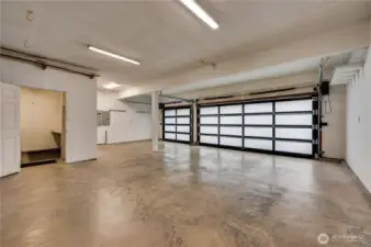 3 car garage with updated doors. The 3rd stall is about 15 feet, to make room for the laundry area to the left. This laundry backs to the den.  It seems possible to relocate the laundry to the den area, if desired.