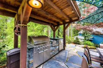 This spectacular covered, outdoor kitchen has a 9 foot counter; large grill, two burners, 2 Haier refrigerator drawers and lighting.