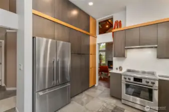Beautiful custom two-toned wood cabinetry stretches to the ceiling, providing tons of storage space, and high-end stainless appliances nurture your inner chef.
