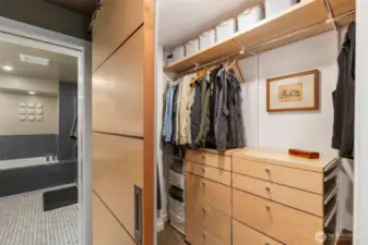 Thoughtfully-designed custom closets in the primary suite with sliding wood doors and built-in cabinetry.