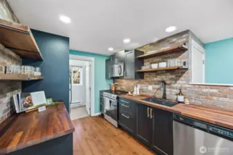 The reclaimed brick backsplash pairs effortlessly with the butcher block countertops