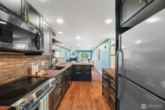 Single-bowl undermount sink with a sleek matte black finish and stainless steel appliances