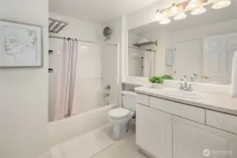 Sparkling clean full bath offers a large vanity with storage space and handsome fixtures.