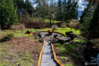 Adjacent to the custom shed is another discrete area for your bonfires and late night discussions. Below this area is a seasonal creek that winds through the property.