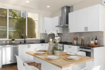 Corner chef's kitchen are equipped with luxury stainless steel appliances, elongated windows allowing an influx of natural light, and modern custom cabinetry.
