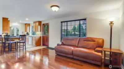 The family room flows effortlessly into the open kitchen, while large windows fill the space with warm, natural light.