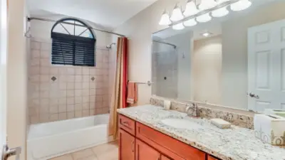 Upstairs full bathroom with charming arched window.