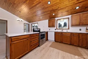 Newly updated kitchen with new stove, flooring, countertops, and backsplash.