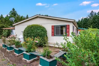 Backyard includes adorable benches and gardening pots on top of laid brick