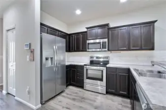 Kitchen view, I love the contrasting cabinets with countertops, all appliances included, and to your left down the hall is your pantry.