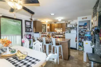 Dining room view looking into kitchen with bar seating