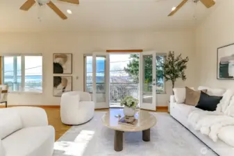 Living room with White oak hardwood floors, skylights and ceiling fans and doors out to deck.