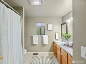 The large main bath has a bathtub and tiled floor.