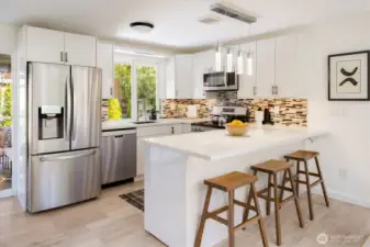 Updated kitchen with quartz countertops, custom cabinetry, and stainless appliances. Image from earlier listing in Sep 2025.