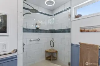 The walk in shower has beautiful tile work.