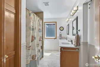 Upstairs full guest bath with tile floors and dual vanity. Linen closet too.